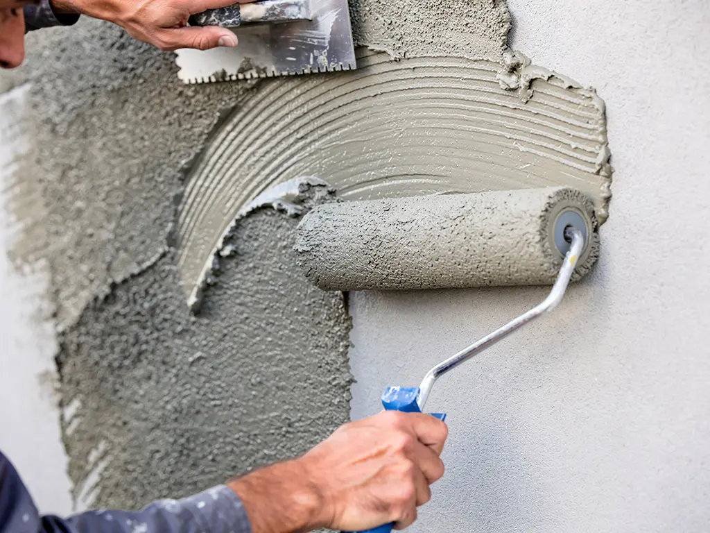 Finition d'un enduit de façade au platoir et mise en teinte au rouleau